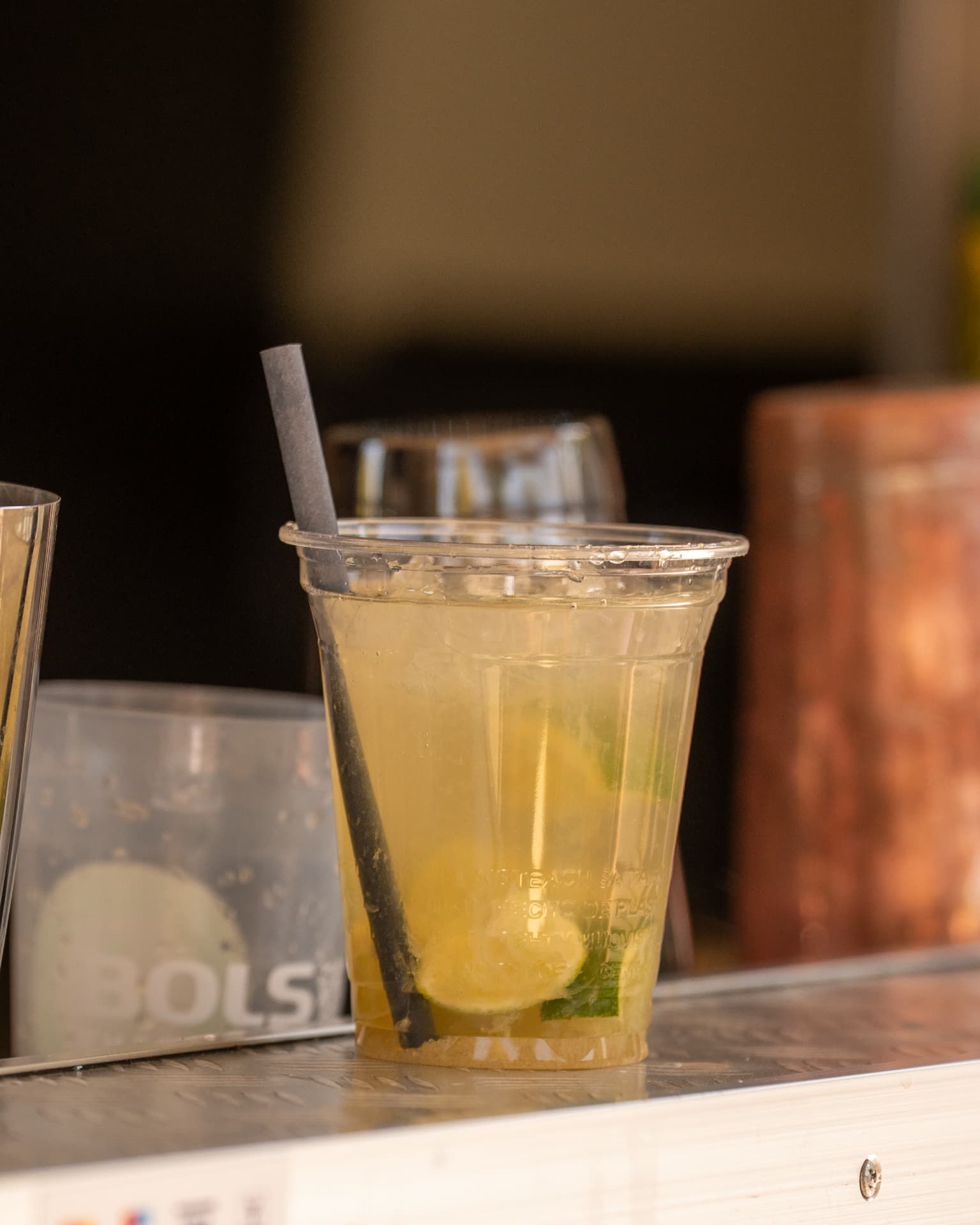 Gelber Cocktail mit Limettenscheiben und Trinkhalm