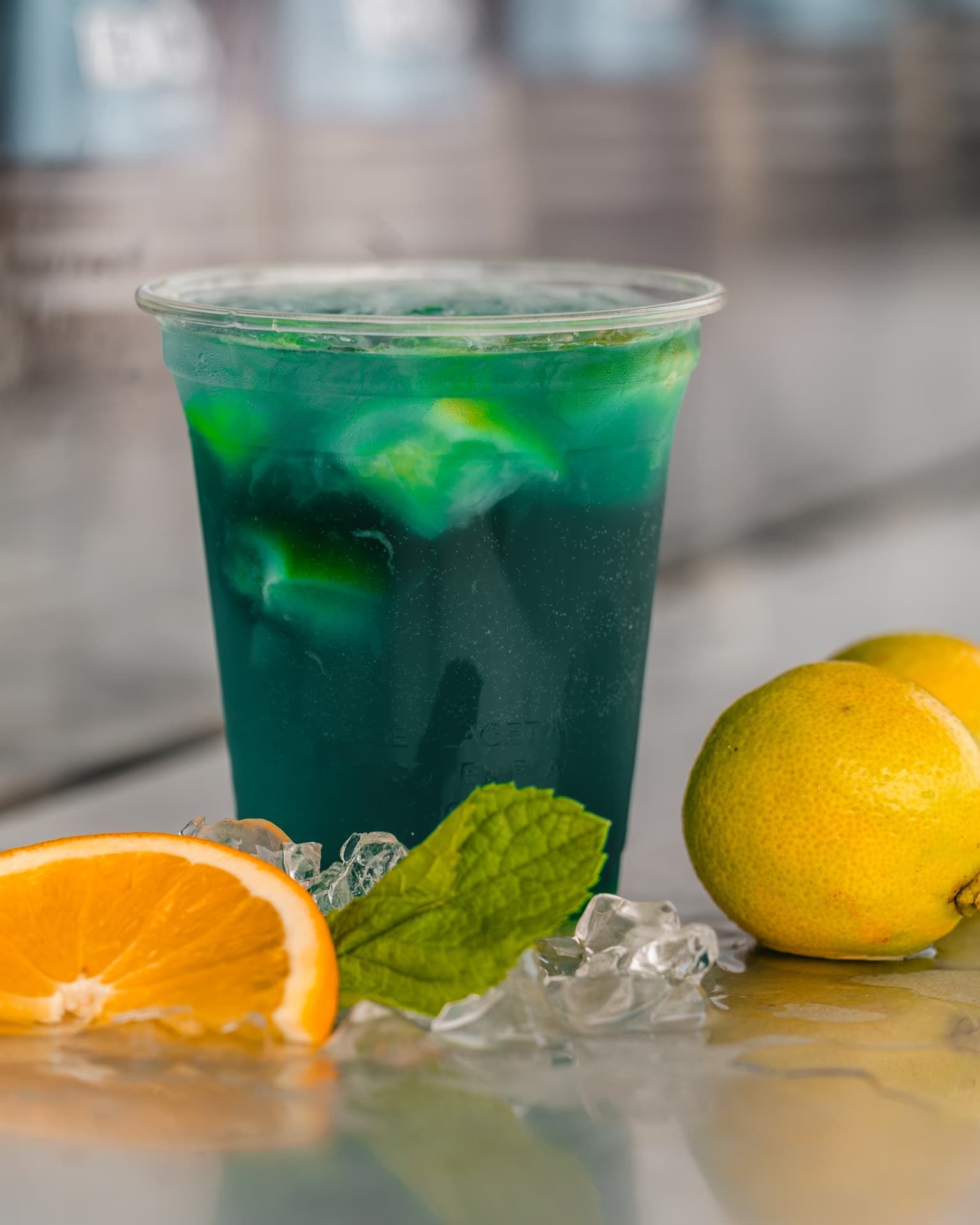 Tiefgrüner Cocktail auf Crushed Ice mit Minze und Zitrusfrüchten