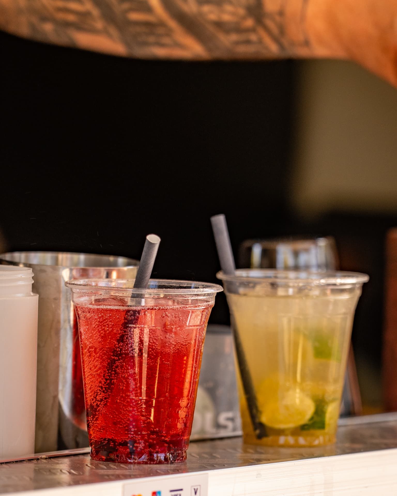 Zwei Drinks nebeneinander: ein roter Longdrink und ein gelber Mojito