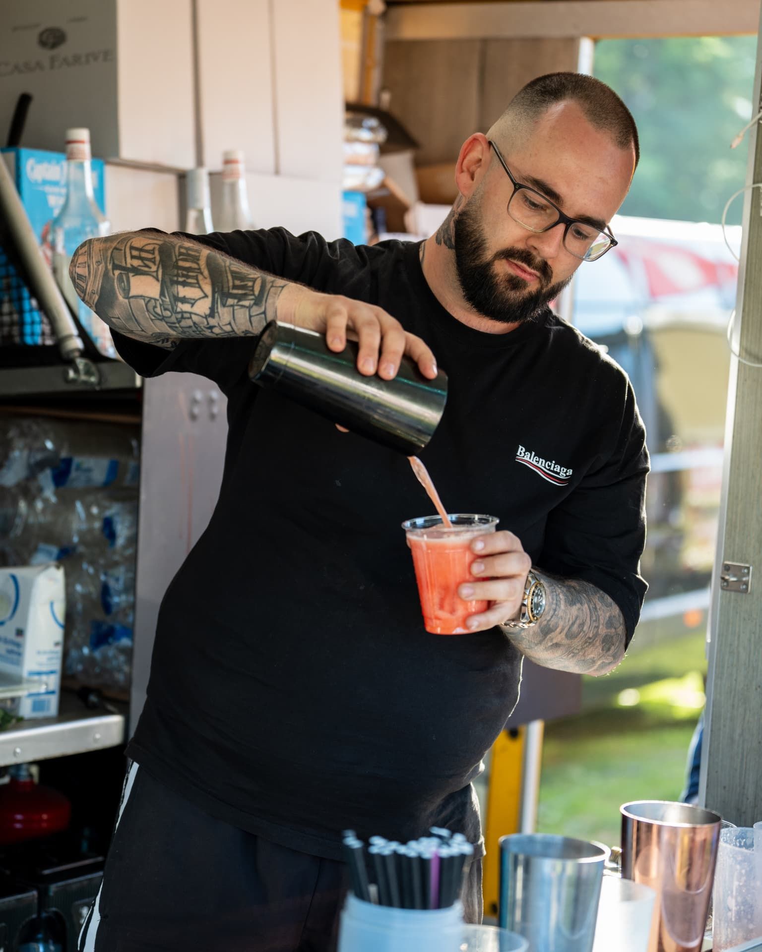 Fertiger Cocktail wird aus dem Shaker in den Becher gegossen