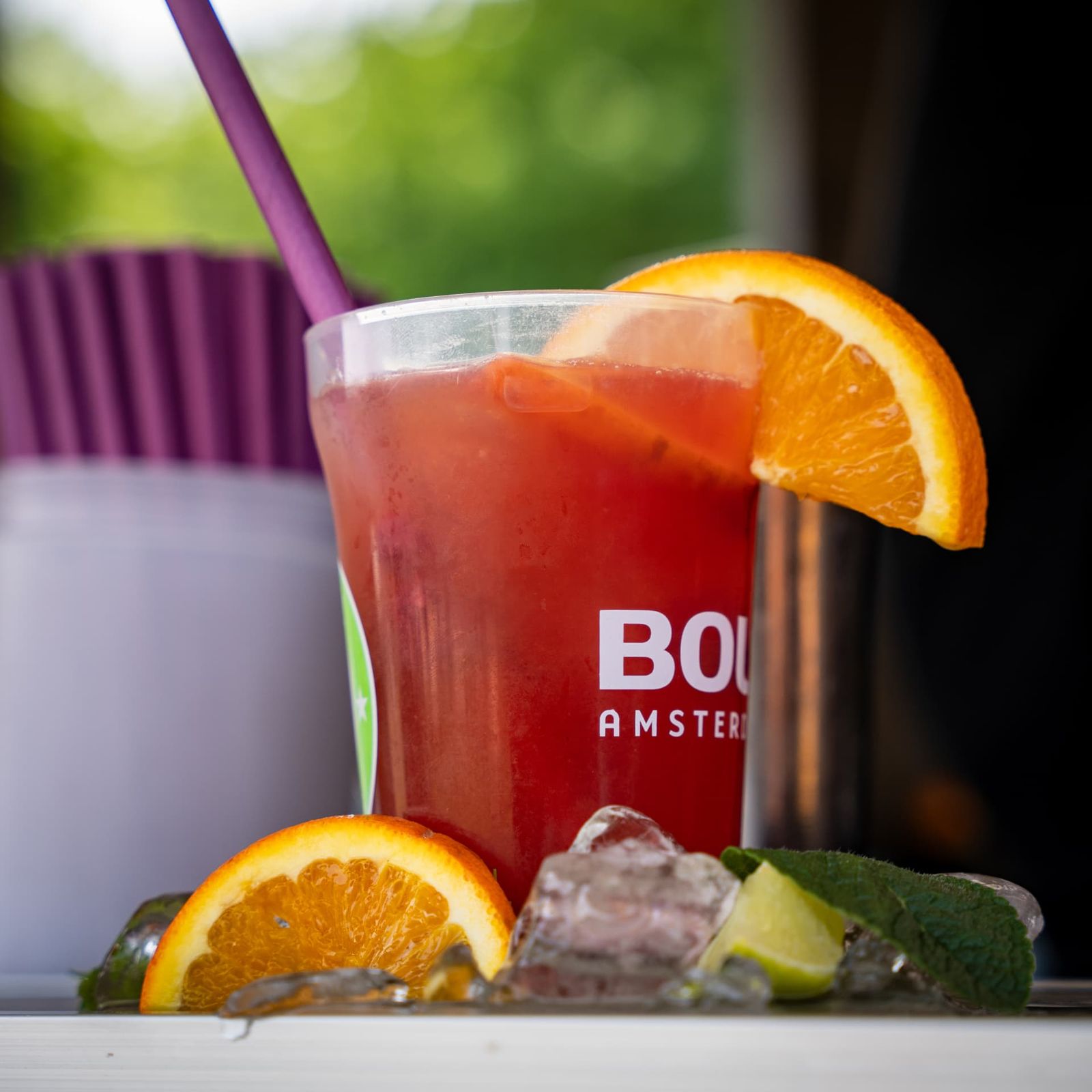 Roter Cocktail mit Orangenscheibe auf Eis